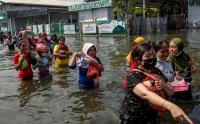 Karyawan Terpaksa Melintasi Banjir Rob yang Menggenangi Kawasan Industri Pelabuhan Semarang