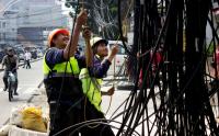 Pekerja Tertibkan Kabel Semrawut di Jalan Pecenongan