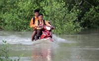 Potret Pelajar Menggunakan Sepeda Motor Terobos Banjir