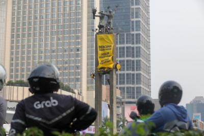 Aktivis Greenpeace Bentangkan Spanduk di Bundaran HI