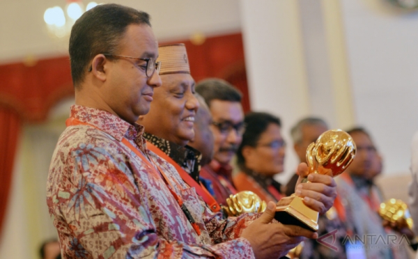 Senyum Anies Baswedan Terima Penghargaan JKN-KIS Award dari Presiden Jokowi